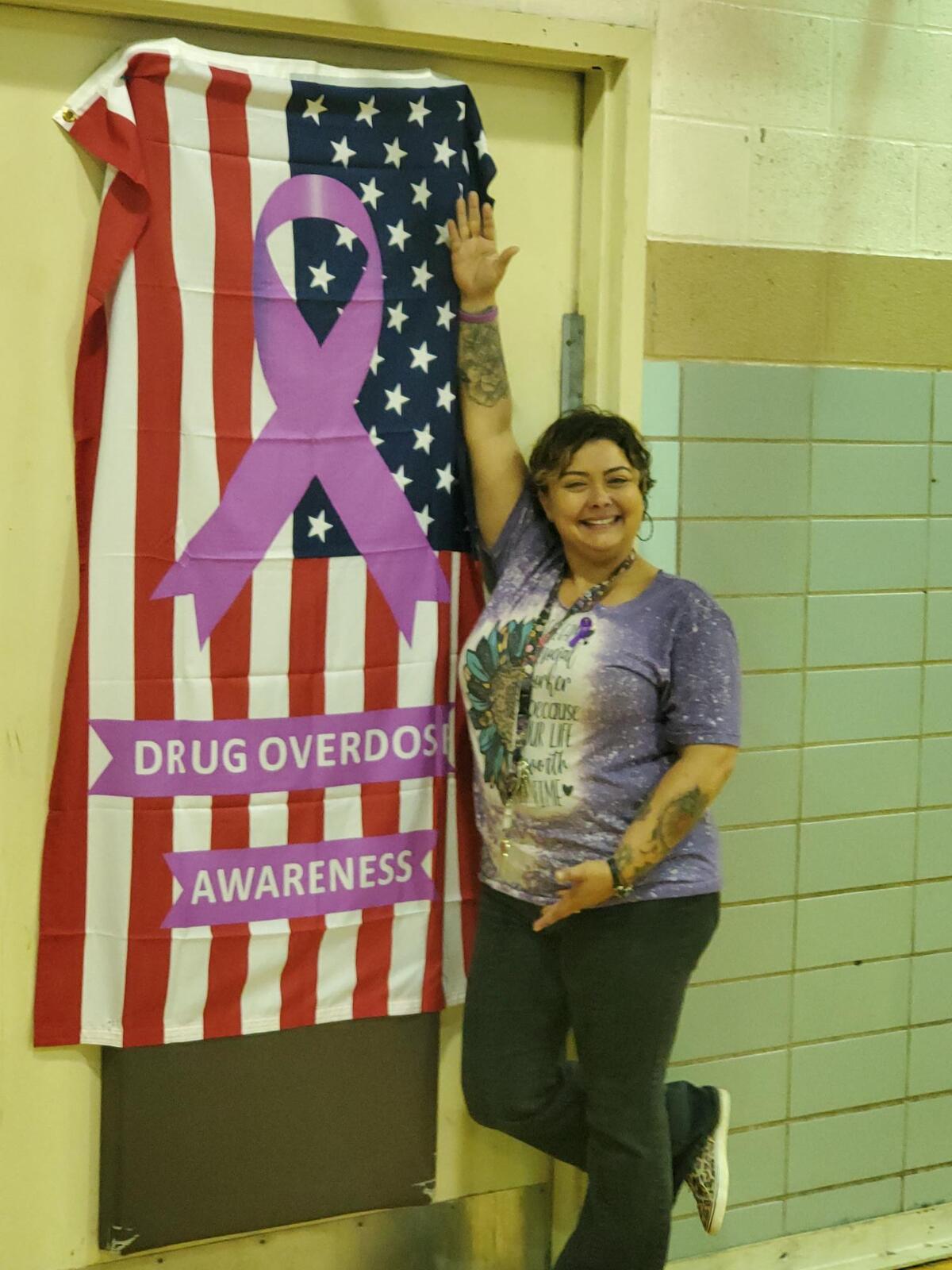 Woman standing with US Flag with Drug Overdose Awareness ribbon